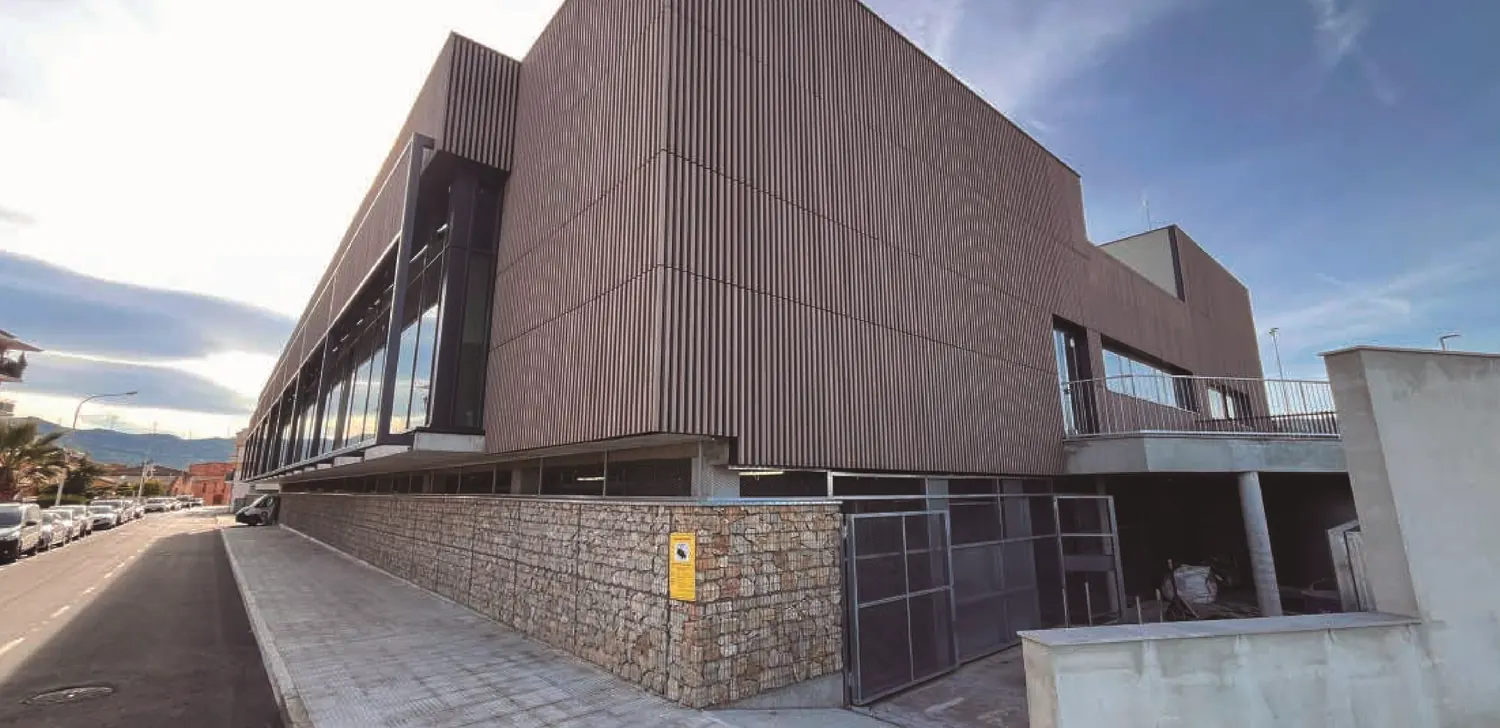 A sports complex with a timber-clad facade and a stone base